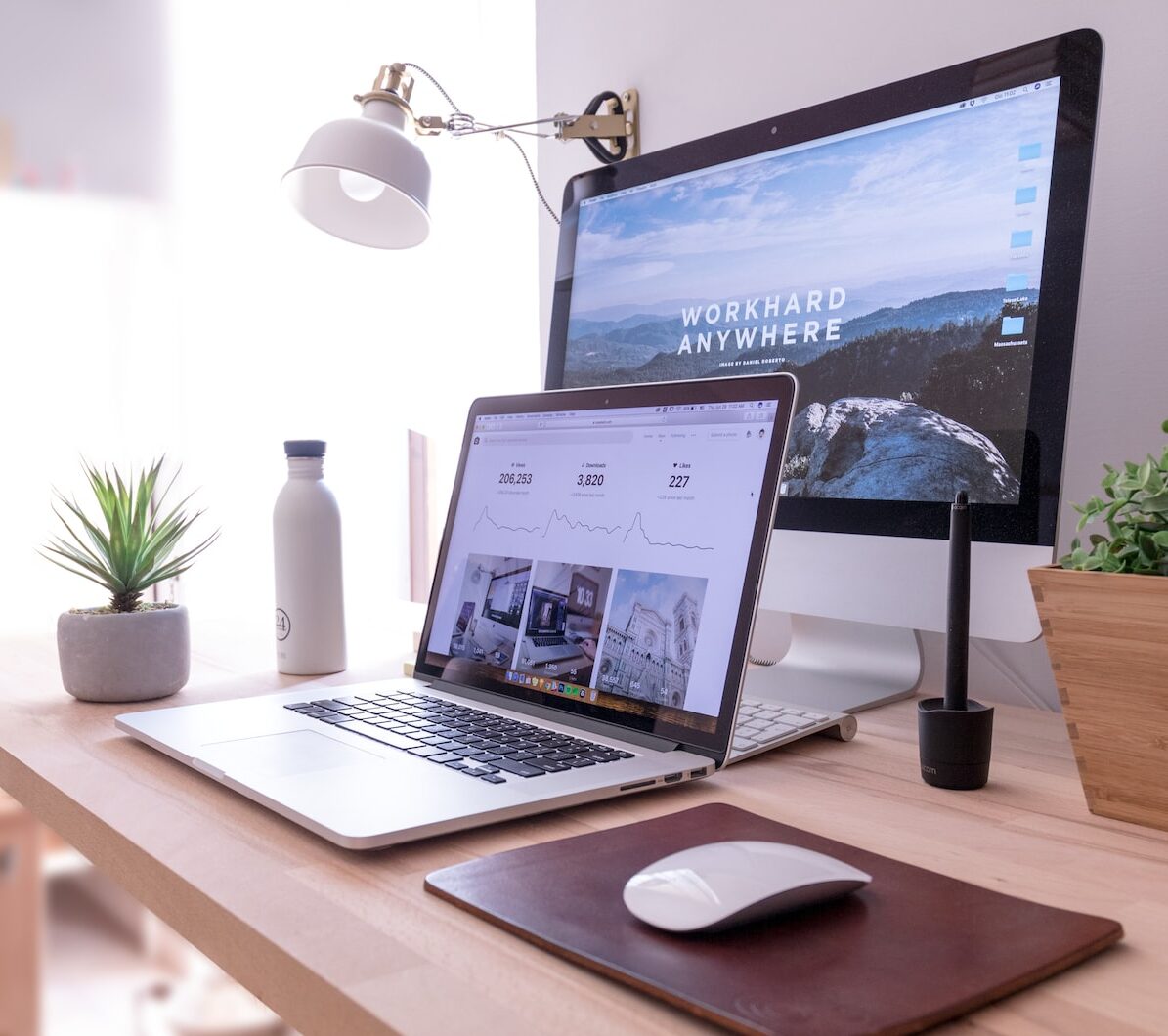 MacBook Pro on table beside white iMac and Magic Mouse